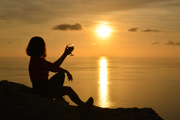 向夕阳敬酒的女人。图片下载