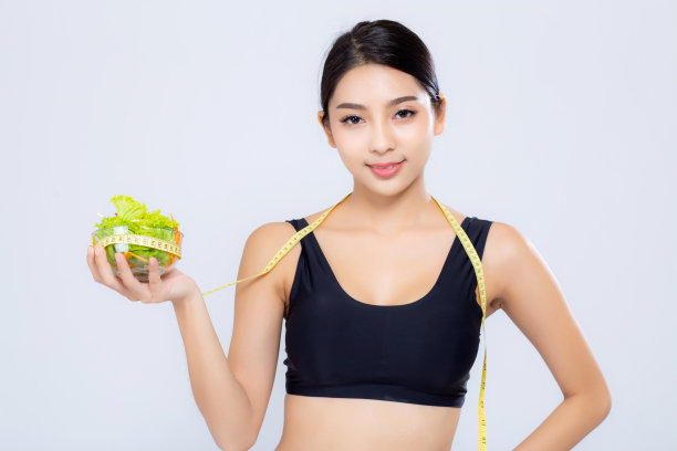 肖像亚洲女人微笑着保持和测量绿色苹果水果和美丽的身体饮食与健康孤立在白色的背景，女孩体重苗条与脂肪团，健康和健康的概念。图片下载