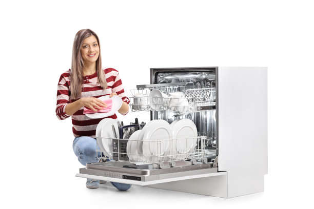 一名年轻女子在洗碗机旁擦盘子，并看着摄像机图片下载