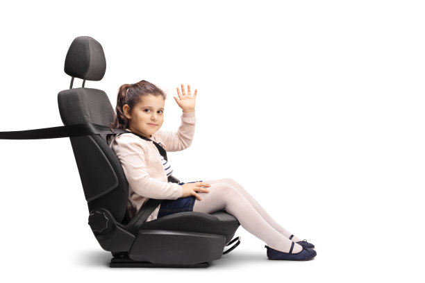 小女孩坐在汽车座椅上系着安全带，看着镜头挥着手图片下载