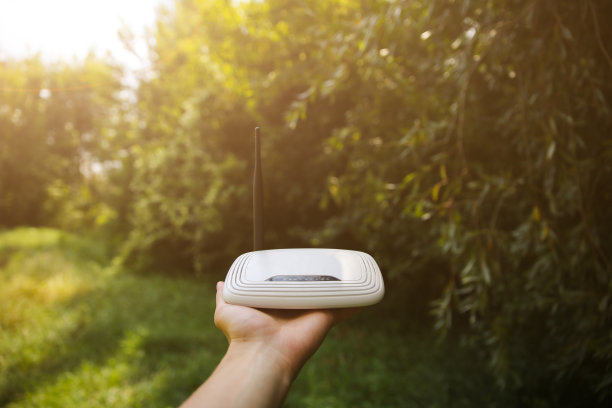 人类在大自然中寻找无线信号。一个人迷路了，手里拿着路由器在寻找网络连接。现代技术的概念。夏季森林照片。图片下载
