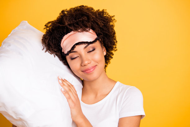 近距离的照片美丽的惊人的她，她的黑皮肤的女士，手躺着的枕头，不需要，星期六早上醒来，星期天，戴着睡眠面具，休闲的白色t恤孤立的黄色明亮，充满活力，生动的背景图片下载