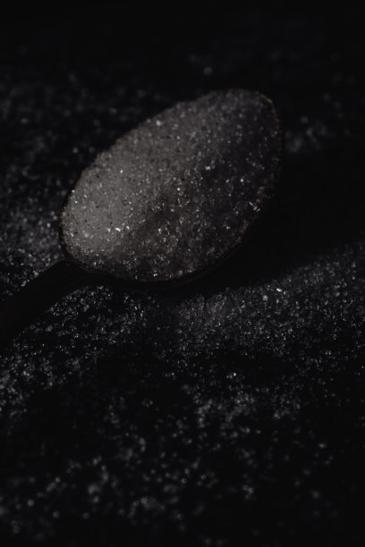 暗照片汤匙与白糖在黑暗的背景，水平的观点，低关键照明图片下载