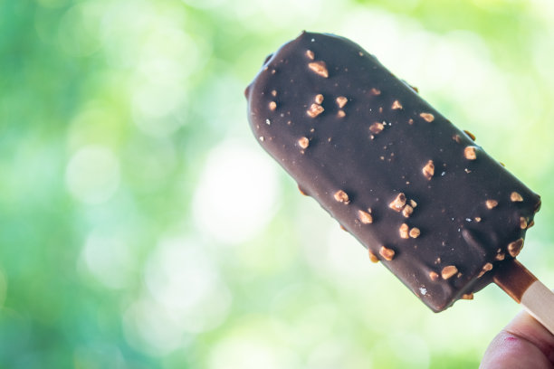 巧克力冰淇淋，手里拿着果仁图片下载