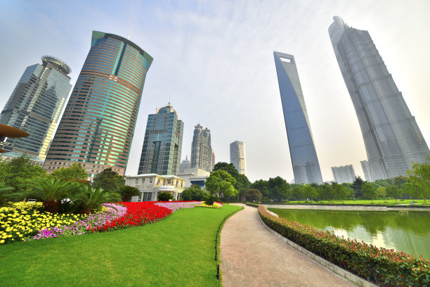 花园里的小草后面是一幢幢高楼大厦。图片下载