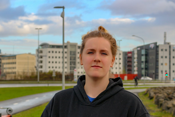 骄傲的女性在商业区前摆姿势，自信的样子，大学生。图片下载