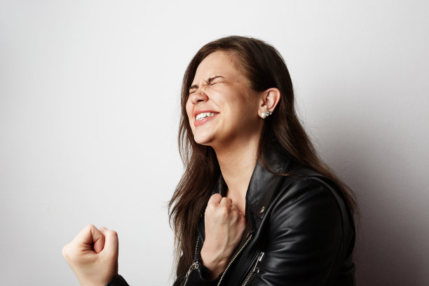 时尚照片美丽的黑发女人穿着皮夹克与黑色的长发摆姿势在白色的空白背景。积极的人类情感，反应，手势。时尚女性的概念。图片下载