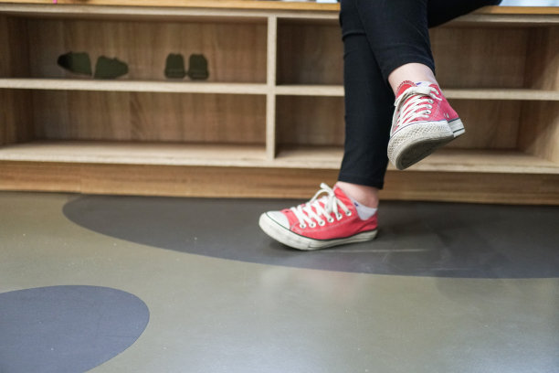 一个女孩的脚和鞋盒在图书馆。图片下载