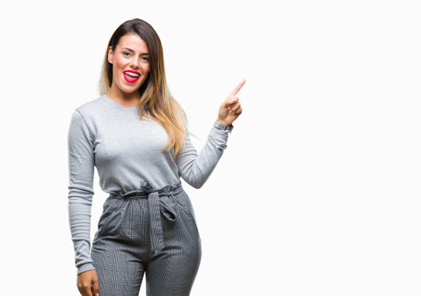 年轻美丽的工人女商人在孤立的背景与一个大大的微笑在脸上，指着与手和手指在一边看着相机。图片下载