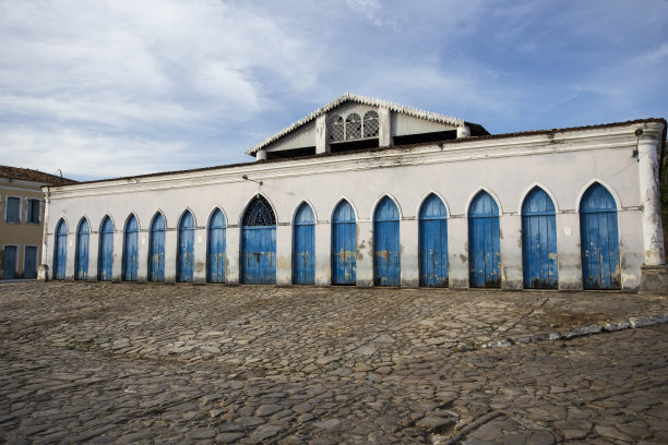 在巴西东北部的一个小城市，一条铺满石头的街道，前面是一个满是蓝色门的市场图片下载