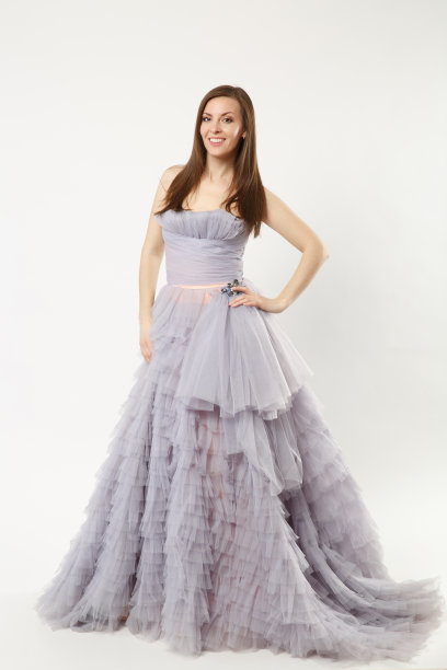 全身照片的时装模特女人穿着优雅的晚礼服礼服摆姿势孤立的白墙背景工作室肖像。黑发长发的女孩。模拟拷贝空间紫色衣服脸视图图片下载