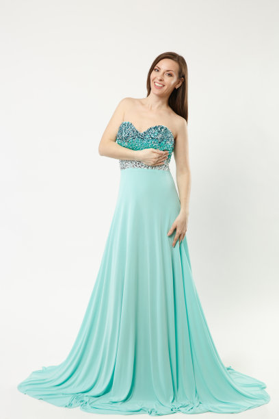 全身照片的时装模特女人穿着优雅的晚礼服礼服摆姿势孤立的白墙背景工作室肖像。黑发长发的女孩。模拟拷贝空间。蓝裙面观。图片下载