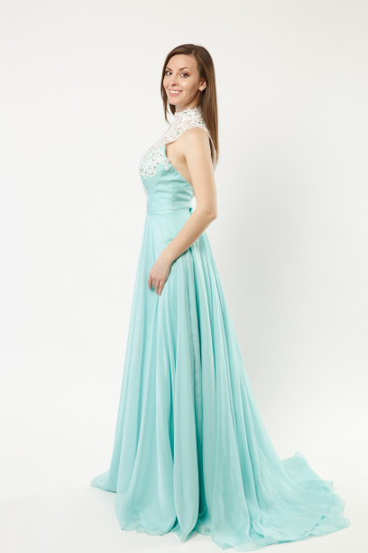 全身照片时装模特女人穿着优雅的晚礼服蓝色礼服摆姿势孤立在白墙背景的工作室肖像。黑发长发的女孩。模拟拷贝空间。侧剖面视图。图片下载