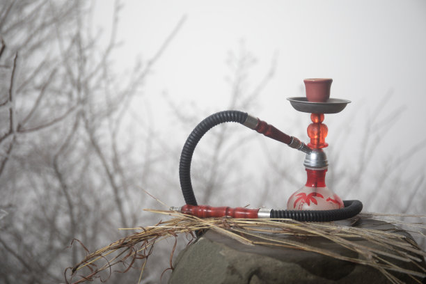 水烟，传统阿拉伯水管，直接日落光，户外照片。山的背景。户外。空的空间。图片下载