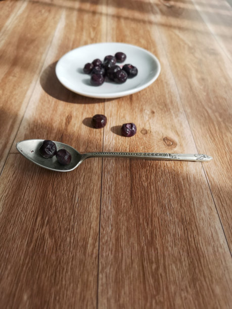 蓝莓放在白色的盘子和复古的勺子里图片下载