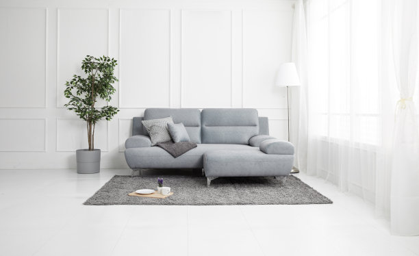 斯堪的纳维亚风格的客厅配有布质沙发、沙发桌。早晨的图像与植物。沙发上的桌子在耳架上。图片下载