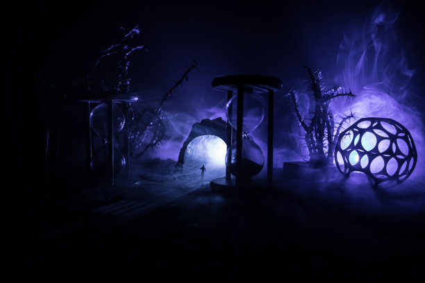 时间的概念。一个男人的剪影站在沙漏中间，在黑暗的背景上有烟雾和灯光。超现实主义的装修图片图片下载