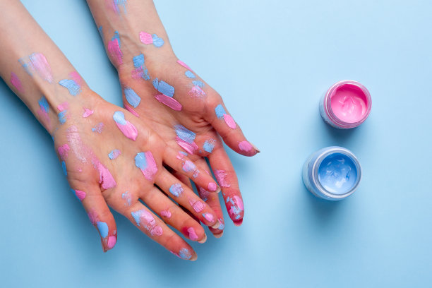 女人的手与水彩笔触在蓝色的背景图片下载