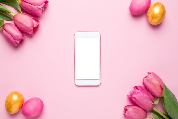 白色屏幕的手机，复活节彩蛋和粉红色背景的花朵郁金香图片下载