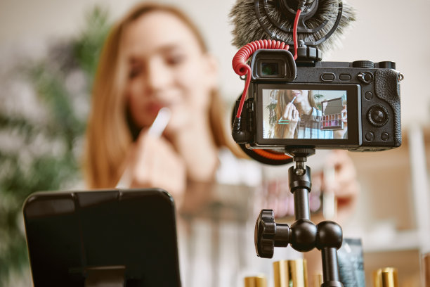 嘴唇。数码相机的特写照片与年轻的博主尝试一种新的口红颜色，同时在社交媒体上在线广播图片下载