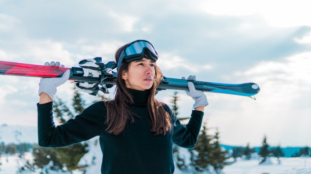 有吸引力的滑雪者的肖像与滑雪镜持有天空图片下载