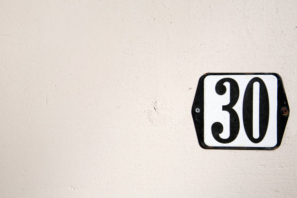 贴在灰泥墙上的30号标签。图片下载