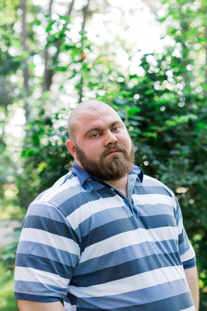 公园里的胖男人看着镜框，一个超重的男人的肖像图片下载