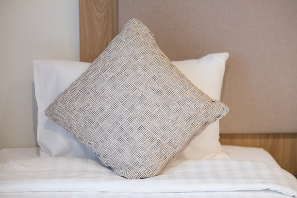 靠近家里舒适的床上的棕色枕头图片下载