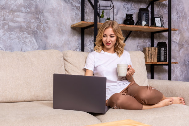 年轻漂亮的女人使用笔记本电脑微笑快乐地看和浏览或做网上购物在家里。图片下载