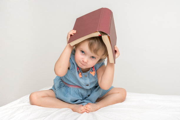 可爱的小孩子穿着蓝色的衣服在看书图片下载