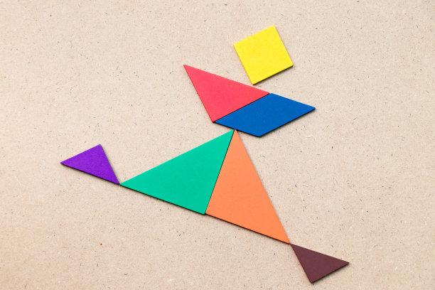 彩色七巧板在奔跑人形状的木材背景图片下载