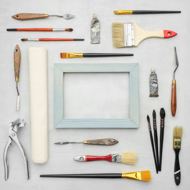 画笔，颜料管，调色板刀，艺术家的帆布卷，木制框架，帆布担架堆在大理石背景。画家供应。前视图。图片下载