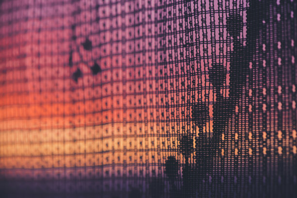 令人惊奇的浪漫日落在窗户后面的轮廓薄纱纹理。美妙的粉红色、橙色、紫色的黎明天空从窗户透过图案窗帘。美丽日出的舒适背景。副本的空间。图片下载