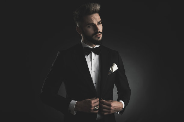 穿燕尾服的男人正在调整他的休闲夹克图片下载