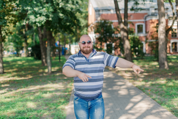 .戴圆框眼镜的年轻人在公园里过胖图片下载