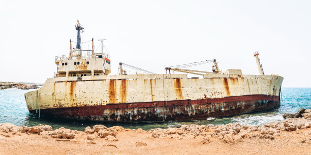 在海岸线上撞毁后，破旧生锈的运输船。图片下载