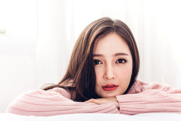 幸福的微笑亚洲女人享受和放松在床上在卧室在家里。亚洲美女图片下载