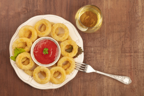 这是一张鱿鱼圈与番茄酱和葡萄酒的照片，从顶部拍摄，背景是黑色的乡村木质，带有复制空间图片下载