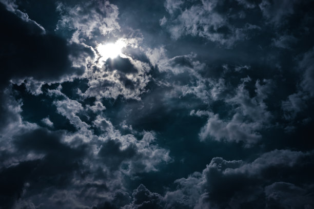 夜晚，月光在乌云后面闪耀。宁静的自然背景。图片下载