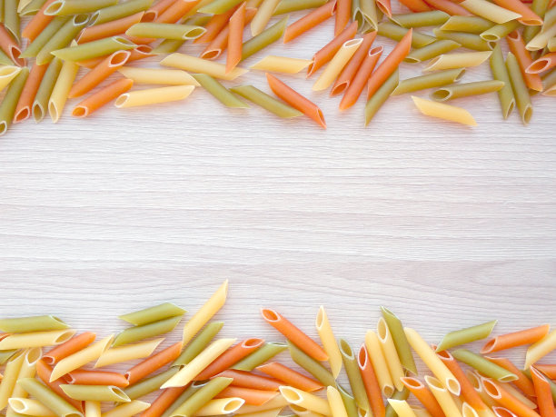 质感的意大利食物背景-彩色的生通心粉在木桌上图片下载