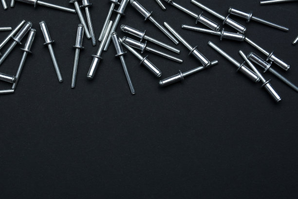 黑色背景的金属铆钉。铆钉。为文本复制空间。垂直布置图片下载