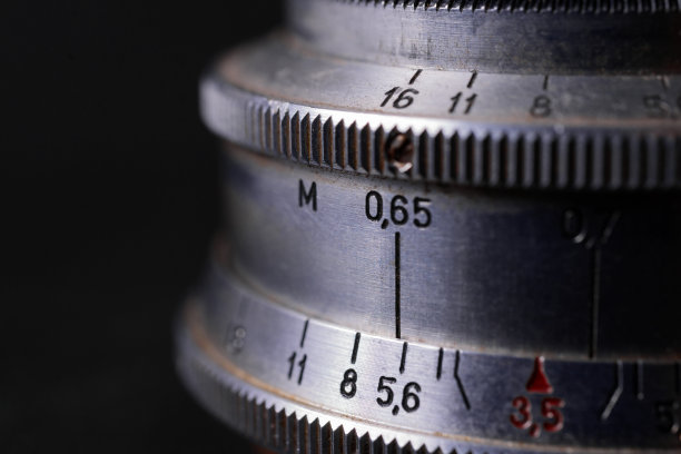复古镜头尺度符号特写。模糊的灰色背景库存照片。镜头上光圈符号和聚焦距离符号。图片下载