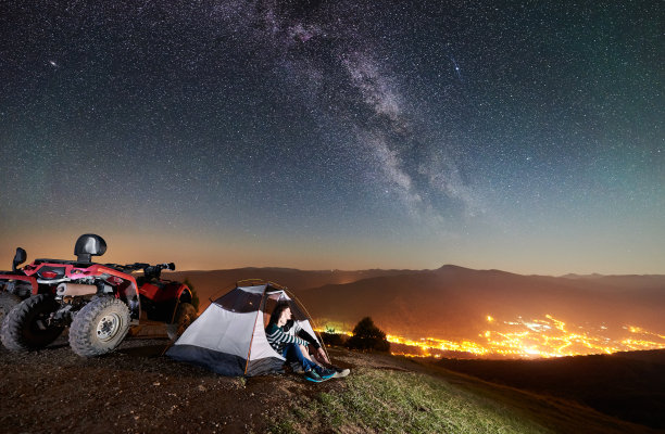 一对游客与atv四轮自行车在夜空下星空图片下载