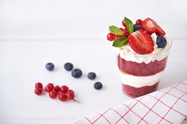 蛋糕甜点俯视图。红丝绒杯，与新鲜浆果，薄荷叶。图片下载