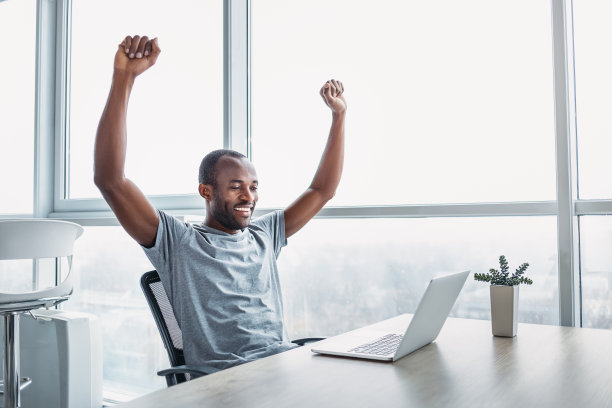 年轻的商人在宽敞明亮的办公室里用笔记本电脑工作。图片下载