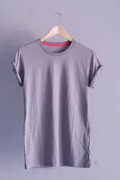 复古折叠灰色棉t恤衣服模型模板在灰色水泥背景概念零售女装店的背景，空白平铺复古灰色墙素朴洗衣广告图片下载
