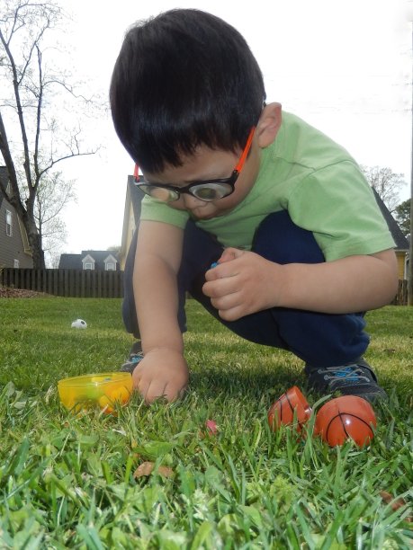 系列一:小男孩在草地上捡糖果图片下载