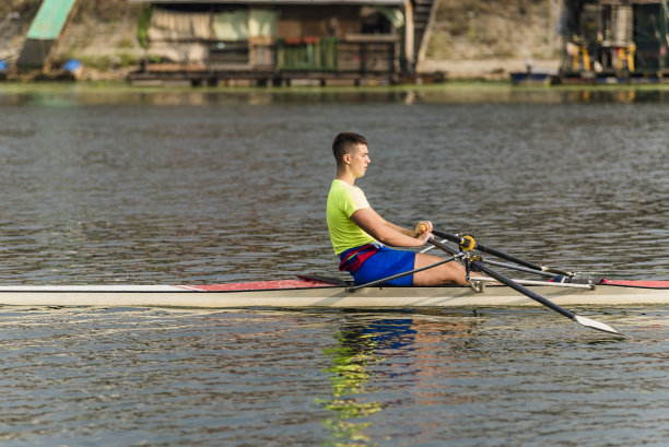 一个阳光明媚的日子，一个男人在河上皮划艇。图片下载