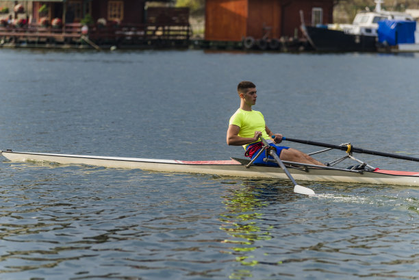 一个阳光明媚的日子，一个男人在河上皮划艇。图片下载
