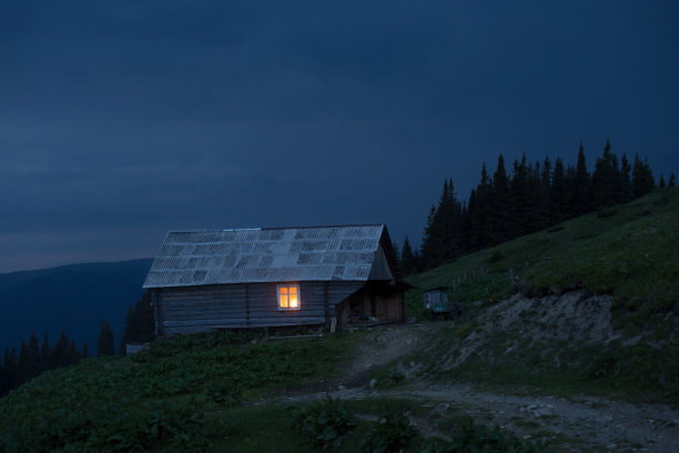 路边的旧木屋。窗户上有光。图片下载